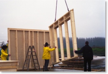 Ein Wanelement in Holzständerbauweise wird auf die erste Schwellenlage gesetzt